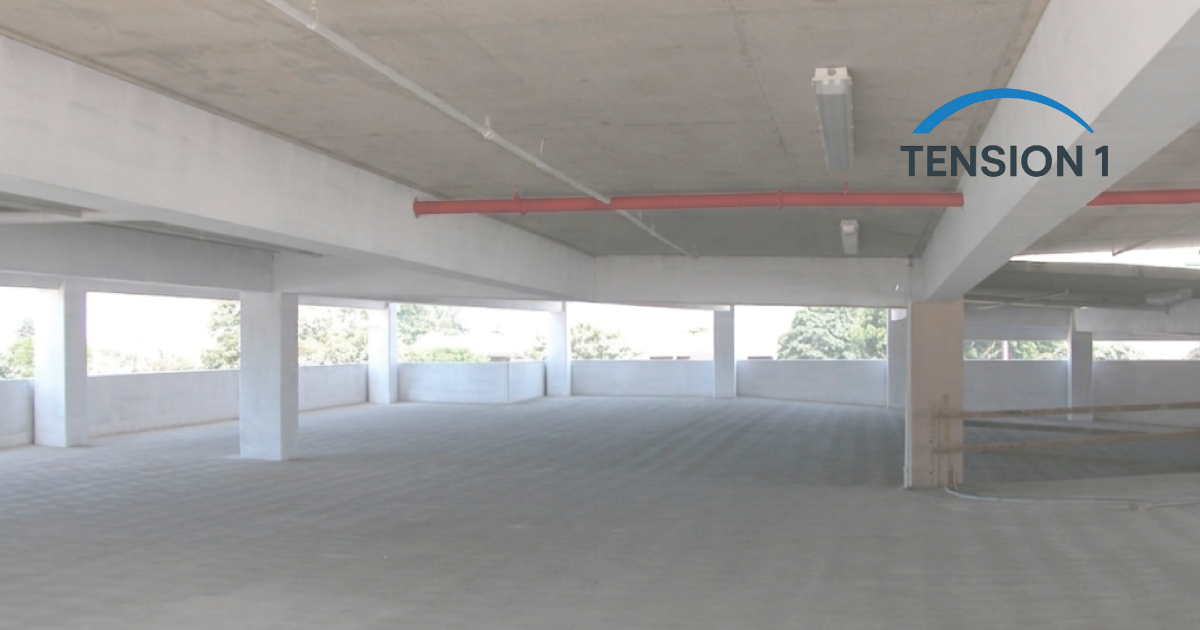 Aerial view of a multi-level post-tensioned concrete parking garage structure under construction in Dallas, TX, with PT tendon layout visible before concrete pour — TensionOne